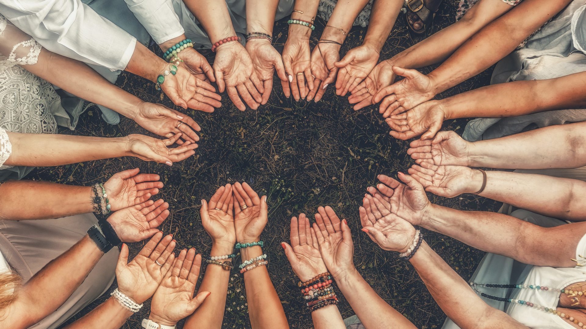 Hands of girls form a circle. Ceremony space | the Yoga Travel Co